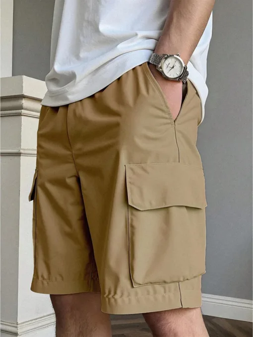 A man wearing a pair of modern, khaki men's cargo shorts with a clean side pocket.
