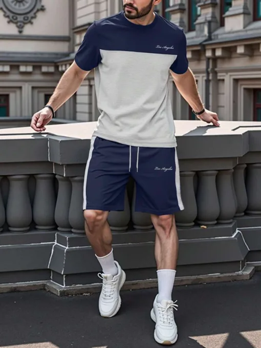 A man wearing a modern navy and grey color-block men's tracksuit.