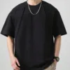 A man wearing a black men's oversize t-shirt with unique seam detailing.