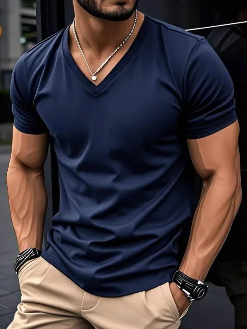 A man with a muscular build wearing a navy blue slim fit men's V-neck t-shirt.