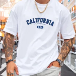 A man wearing a white oversize California t-shirt in a classic collegiate font.